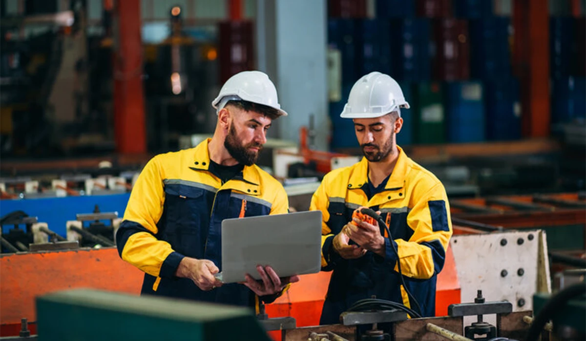 Electro mechanical company in UAE engineers inspecting industrial equipment and reviewing technical operations inside a modern manufacturing facility 